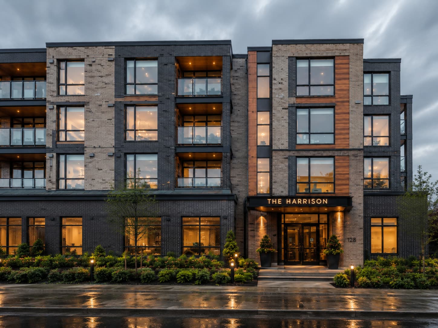 A brick apartment building in the evening, warm lights on